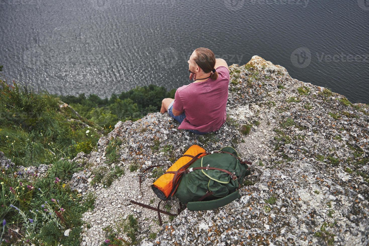 attraktiv man njuter av utsikten över bergslandskapet ovanför vattenytan. resa livsstil äventyr semester koncept foto