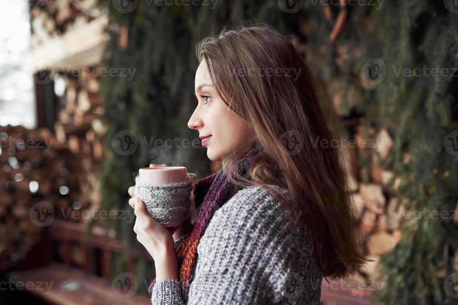 oman bär varma stickade kläder som dricker kopp varmt te eller kaffe utomhus foto