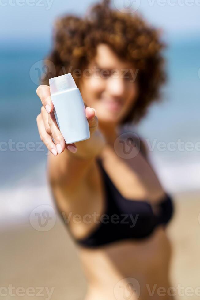 kvinna i bikini som visar kosmetisk produkt foto