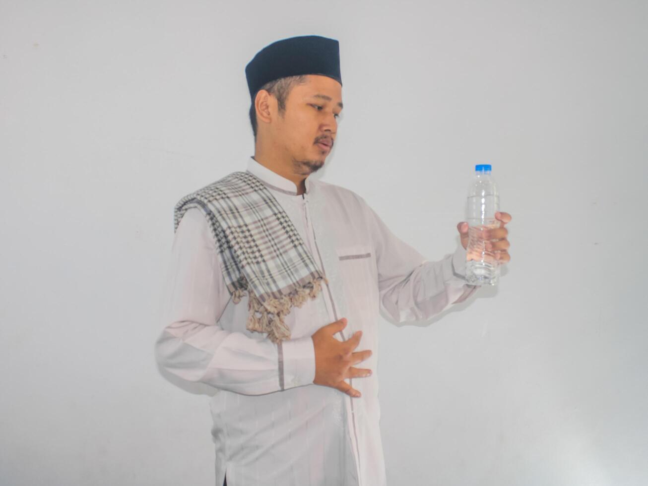 moslem asiatisk man som visar lättad uttryck efter dryck en vatten foto