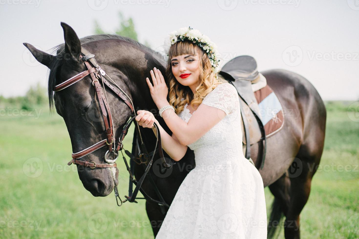 flicka med röda läppar nära en svart häst foto