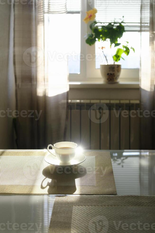 kopp av varm ångande kaffe på en solig morgon- på de kök tabell foto