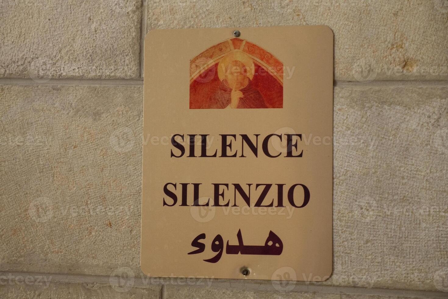 tecken av tystnad i de kyrka på en sten vägg. inskrift i tre språk. selektiv fokus foto