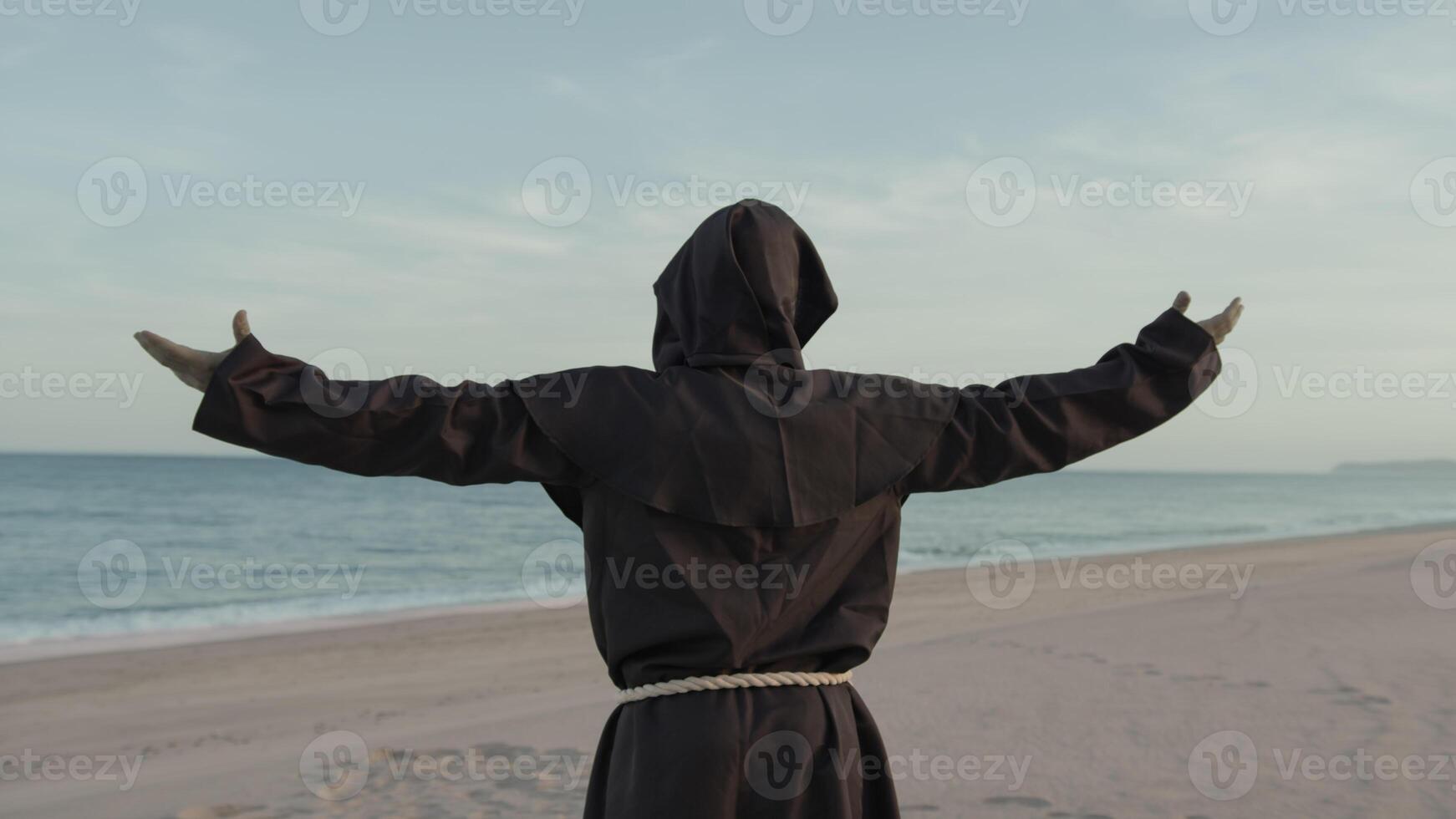 religiös munk med ber mot de hav med öppen vapen foto