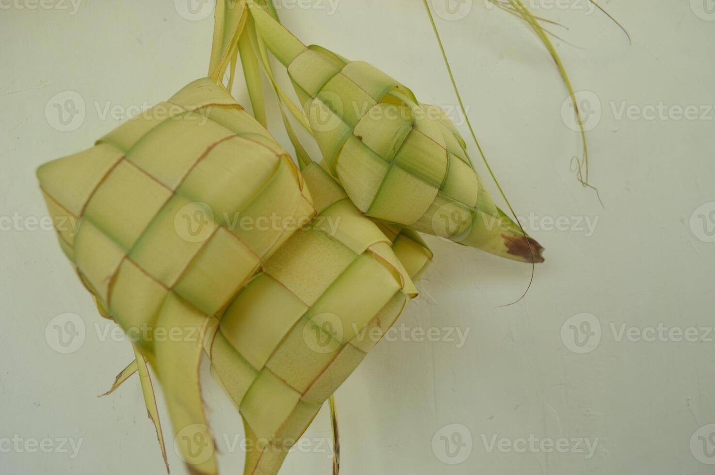 Ketupat isolerat på vit bakgrund. en typisk eid al-fitr maträtt tillverkad från ris insvept i en slå in tillverkad från vävd ung kokos löv. typisk malaysiska och indonesiska mat foto