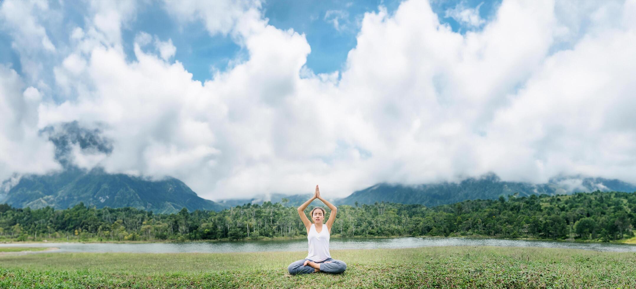 asiatisk kvinnor koppla av i de Semester. spela om yoga. på en grön bete. foto