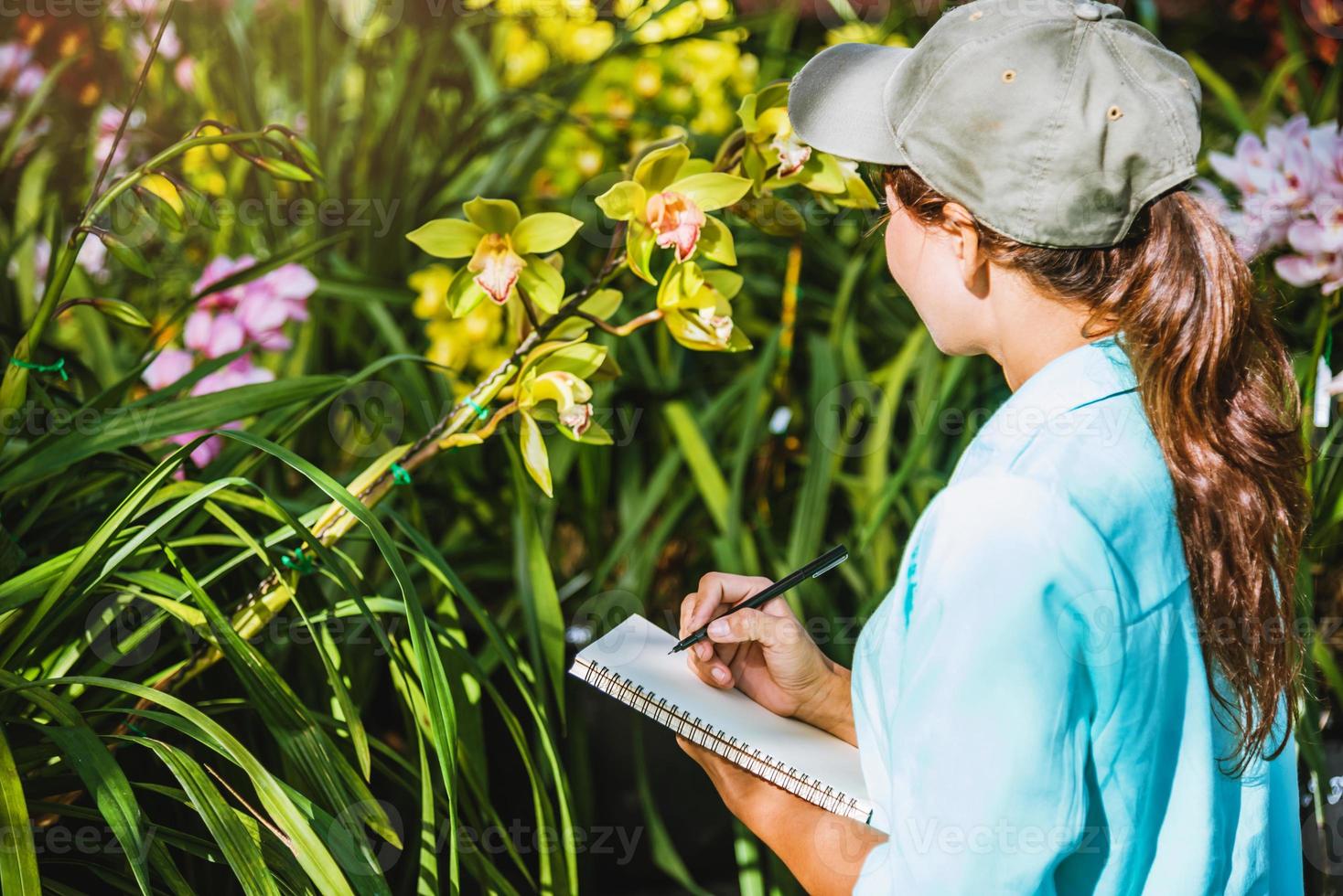 flickan noterar förändringarna, orkidétillväxt i trädgården. vacker orkidébakgrund i naturen foto