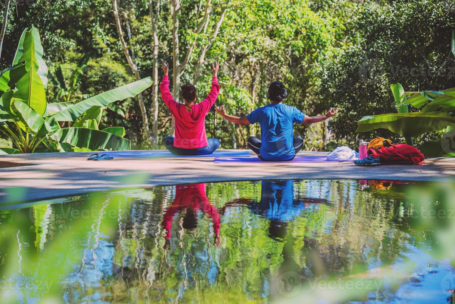 asiatisk kvinna och asiatisk man reser naturen. resa slappna av. yogaställningskoncept, bra hälsovård med yogaställningar. utomhus träning relax yoga. foto