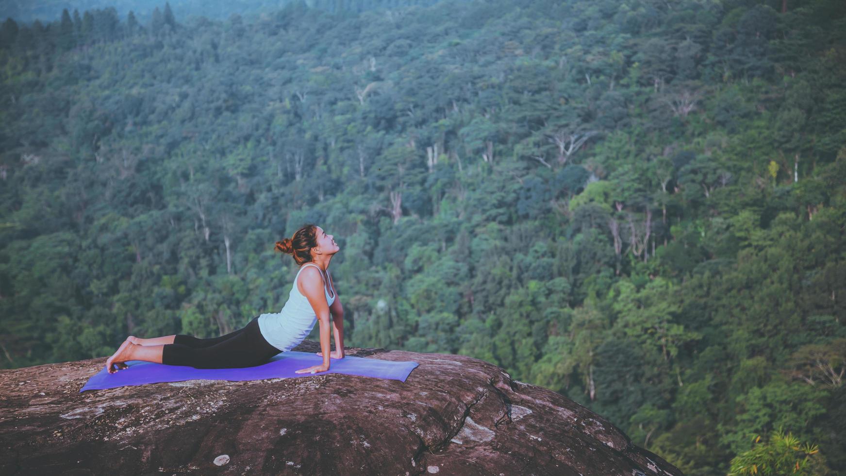 asiatiska kvinnor koppla av i semestern. spela om yoga. på bergsklippan. natur bergsskogar i thailand foto