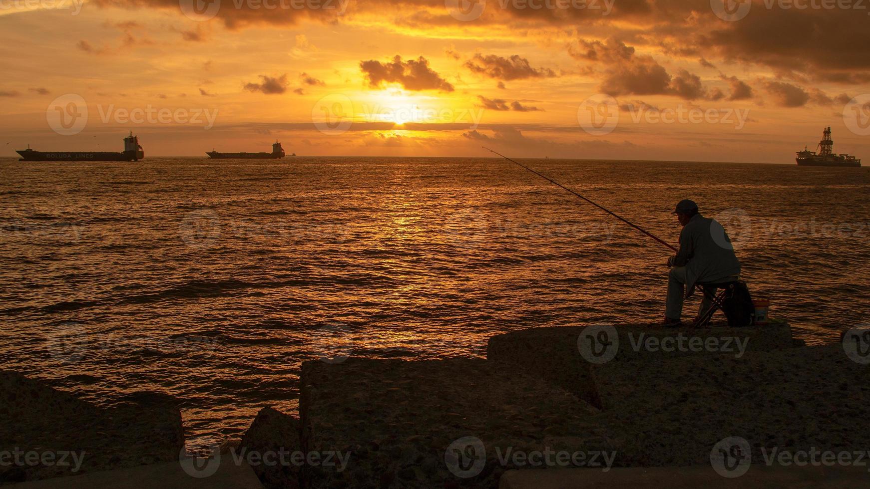 fiskare vid soluppgången vid kusten foto