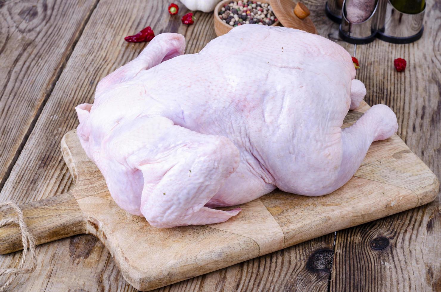 rå kycklingkropp på köksskärbräda. studiofoto foto