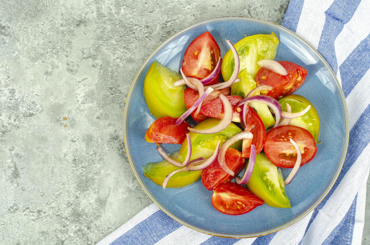 dietmat. sallad av skivor av färska ljusa tomater och lök. studiofoto foto