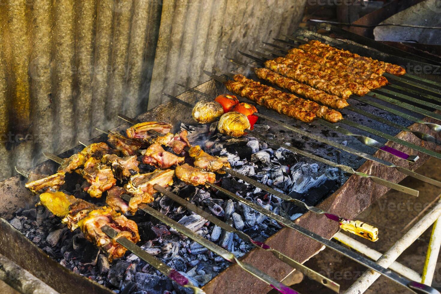 en massa av kebab grillspett på de grill, på de kol närbild i de rök foto