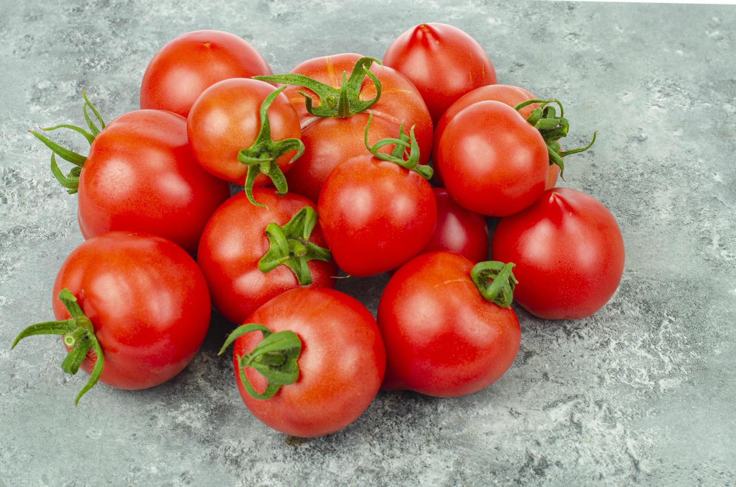 gäng mogna tomater på blå-grå bakgrund. studiofoto foto