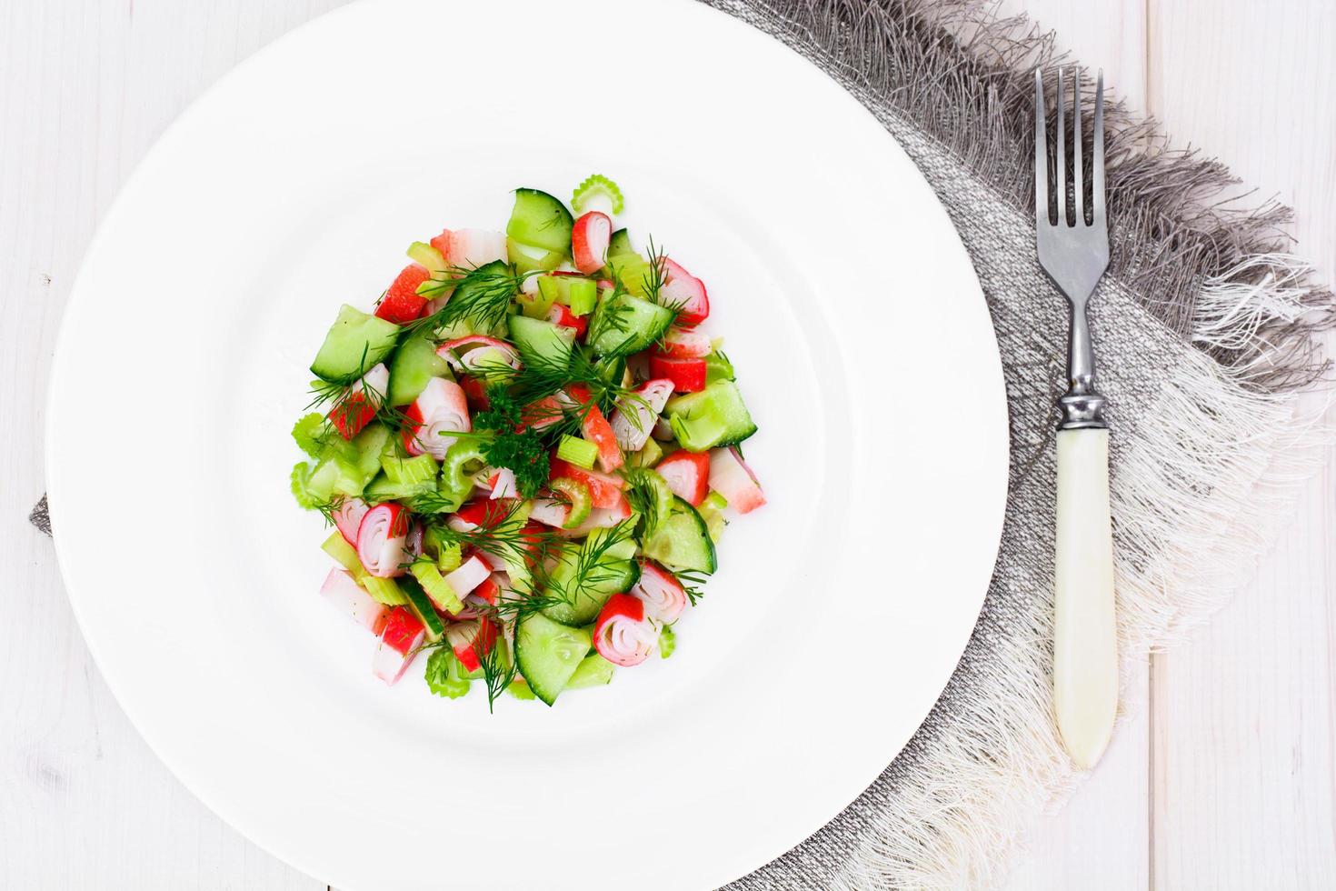 sallad på selleri, krabbsticka, gurka, gröna oliver och dill foto