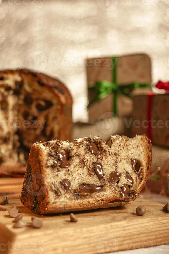 skiva choklad panettone på trä skärbräda med juldekorationer foto