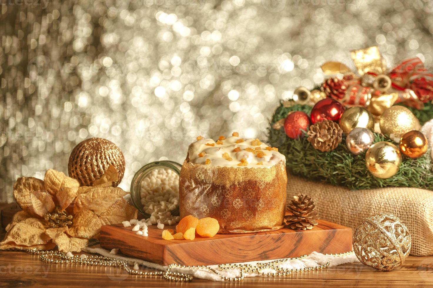 vit choklad panettone med torkad aprikos på träbord med juldekorationer foto