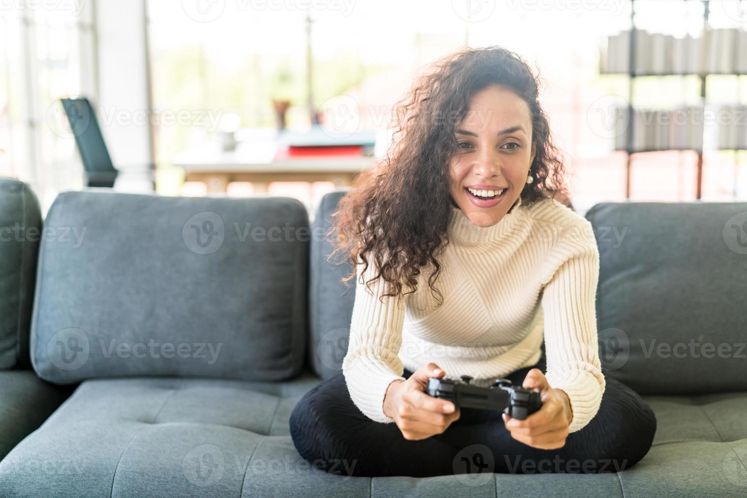 laitinsk kvinna som spelar tv-spel med händer som håller joysticken foto