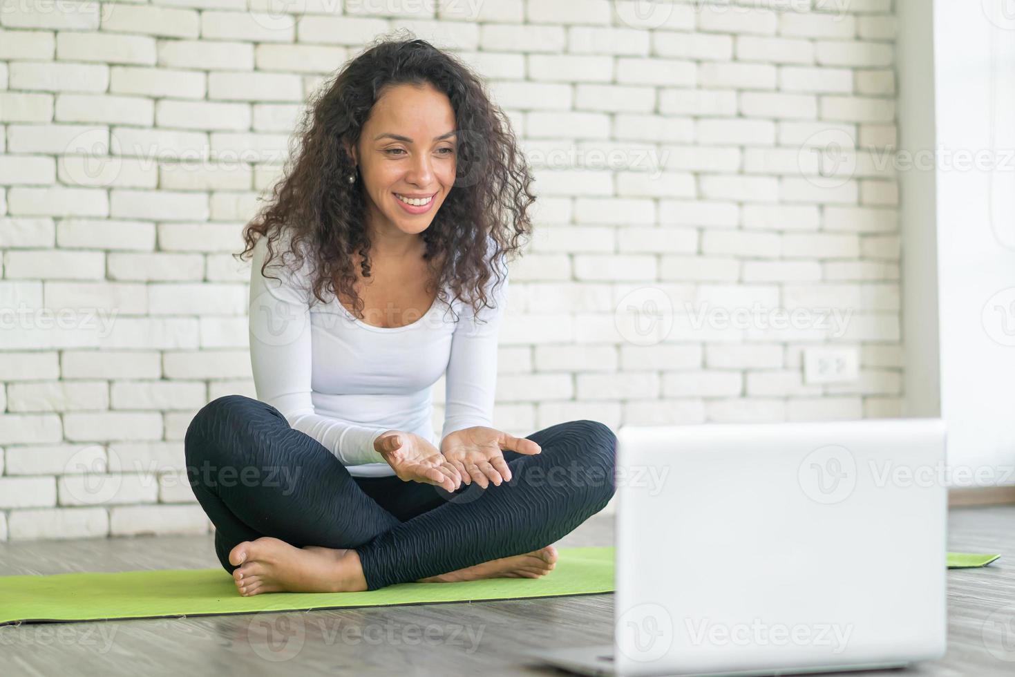 latinsk kvinna som undervisar i yoga online foto