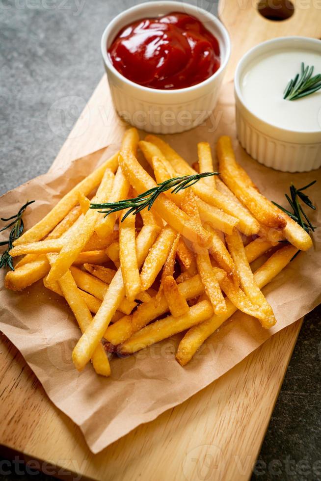 pommes frites med gräddfil och ketchup foto