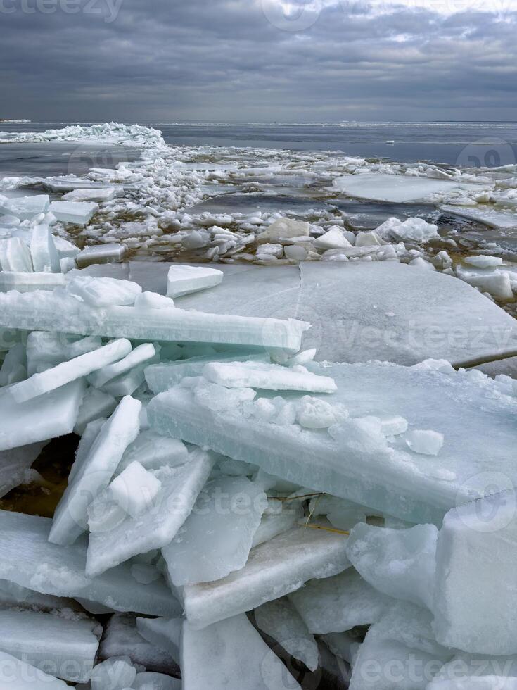 en dramatisk vidd av bruten is ark stretching till de horisont under en lynnig mulen himmel, skildrar en skarp, kall arktisk landskap foto