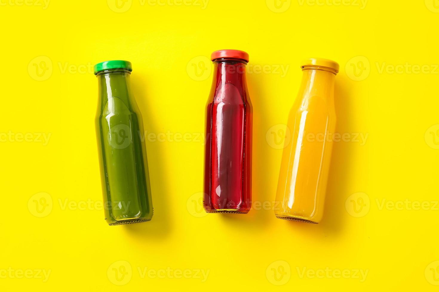 flaskor med hälsosam juice på färgbakgrund foto