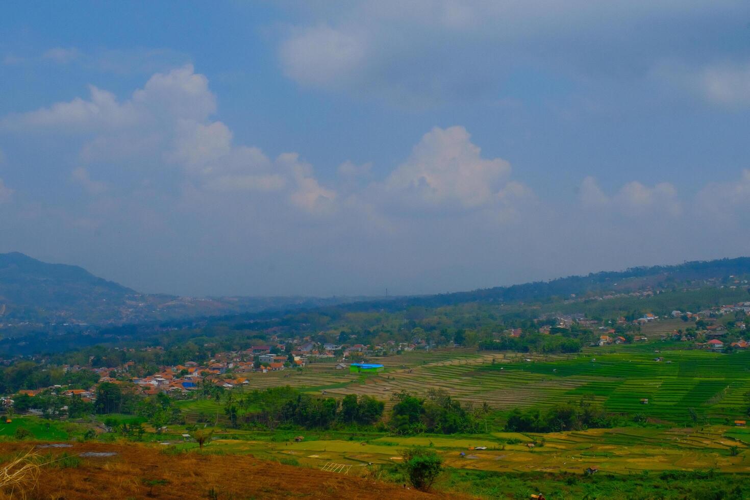 landskap fotografi. landskap se. naturskön natur grön och bördig sluttningar. skön kulle landskap med blå himmel bakgrund. bandung, indonesien foto