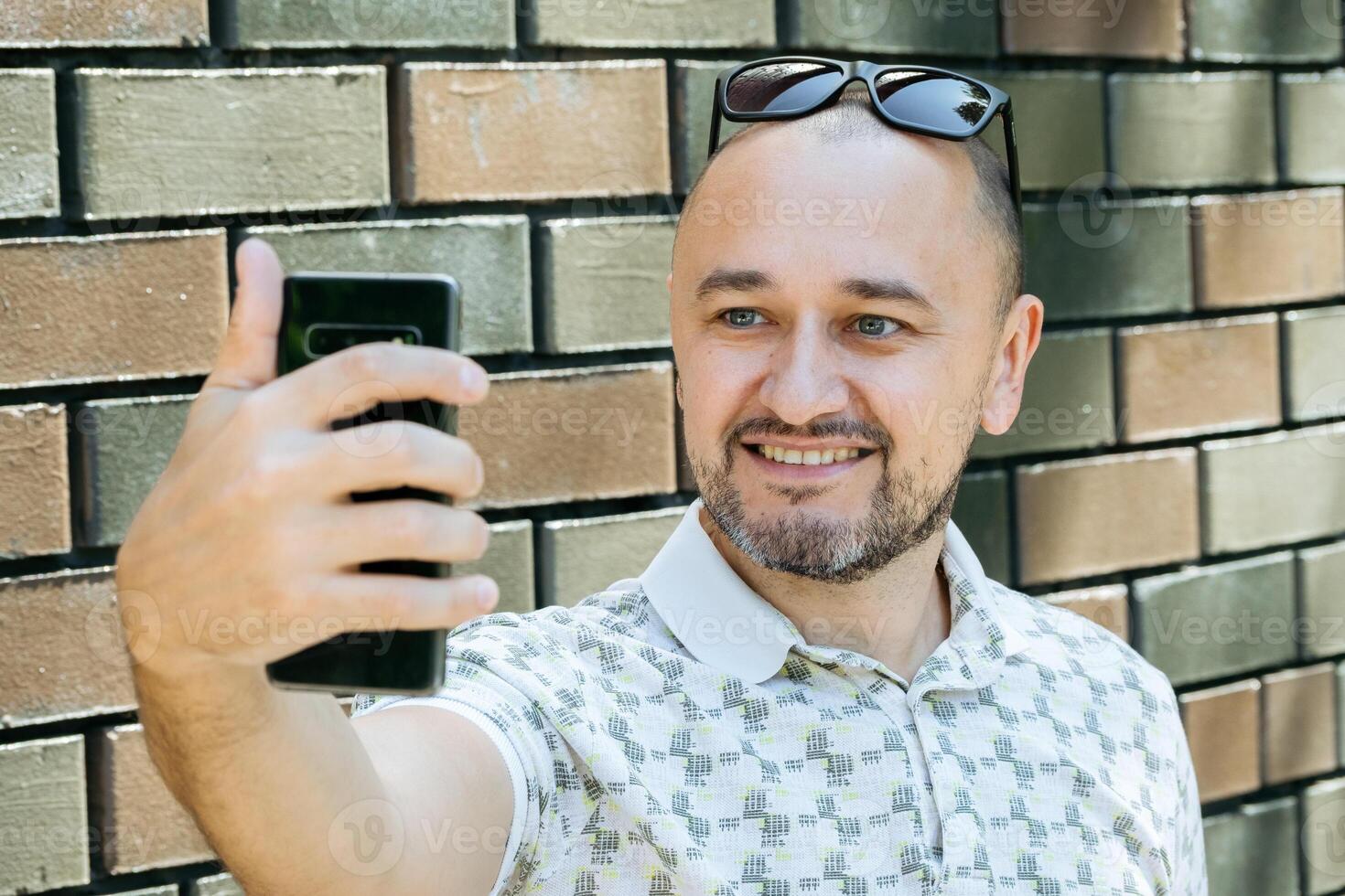 man tar selfie med tegel vägg foto