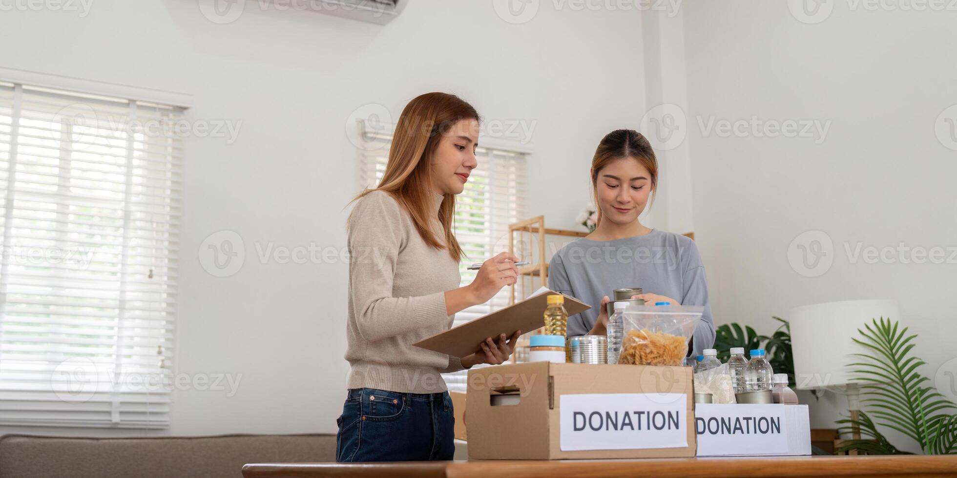 donation och två kvinna volontär- asiatisk av Lycklig förpackning mat i låda på Hem. välgörenhet foto