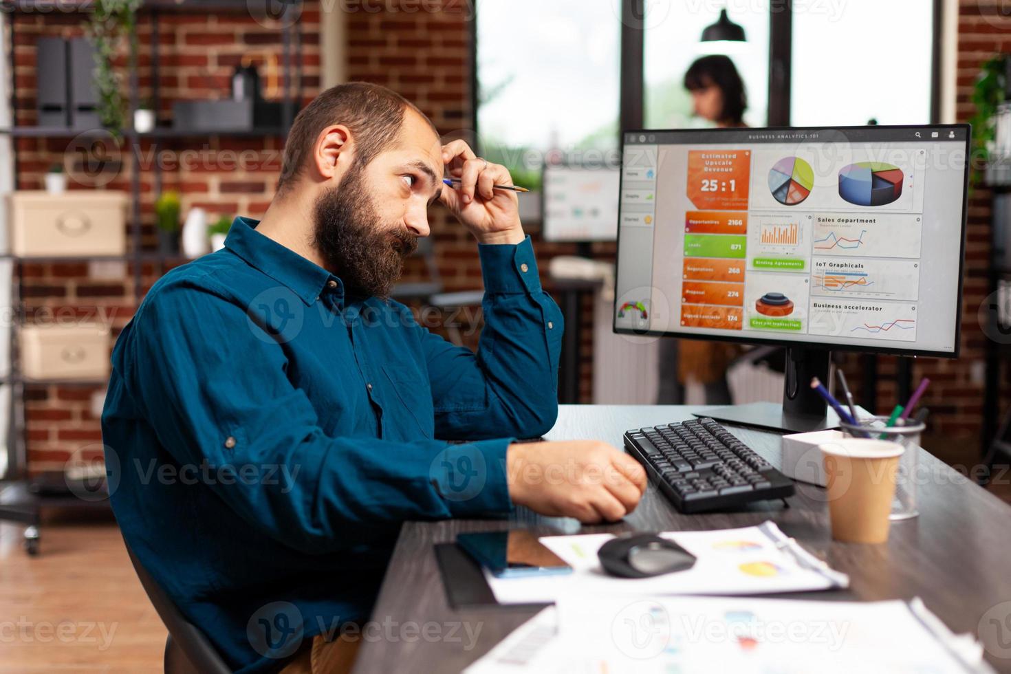 fokuserad eftertänksam entreprenör sitter vid bordet och tänker på projektidéer foto