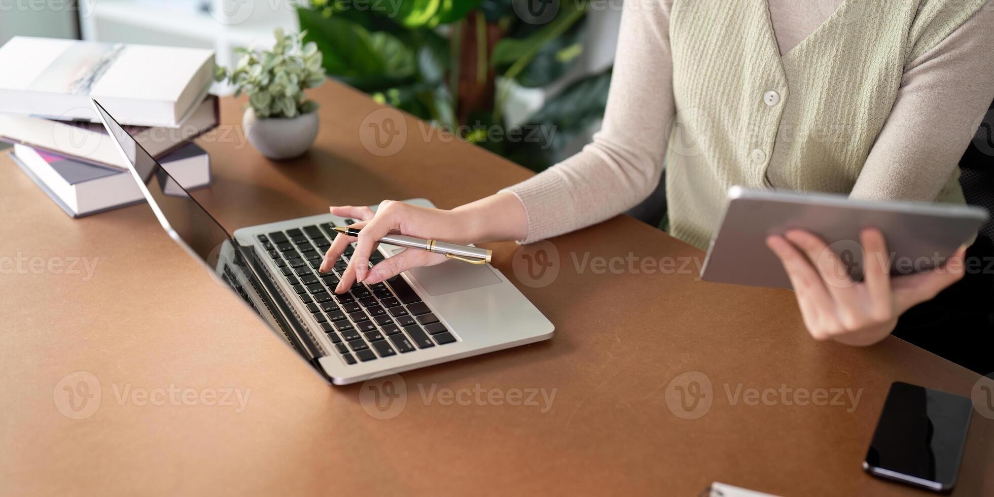 kvinna Sammanträde på skrivbord och arbetssätt på dator bärbar dator och läsplatta pc på Hem foto