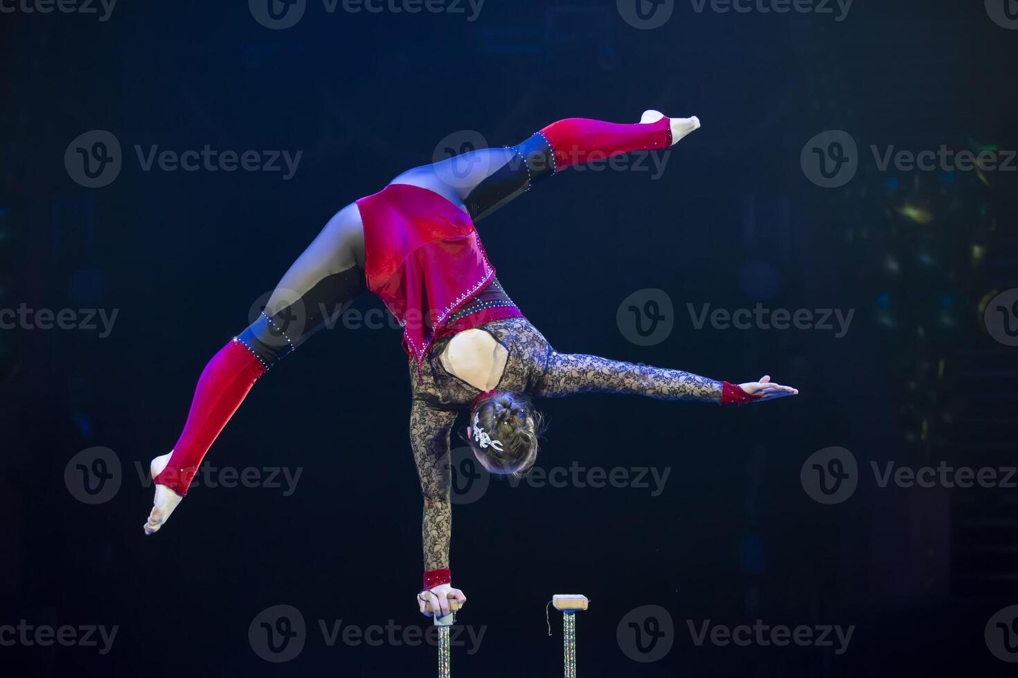 en gymnast utför i en show. en flicka gymnast utför en cirkus akrobatisk prestanda. foto