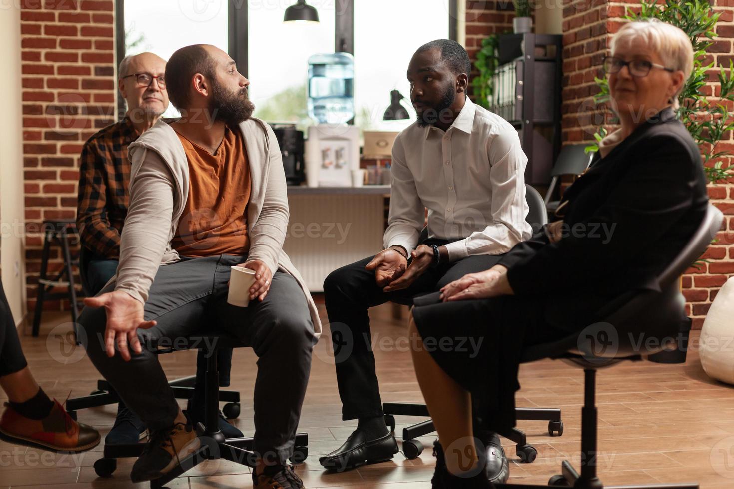 multietnisk grupp människor på ett terapimöte som pratar tillsammans foto