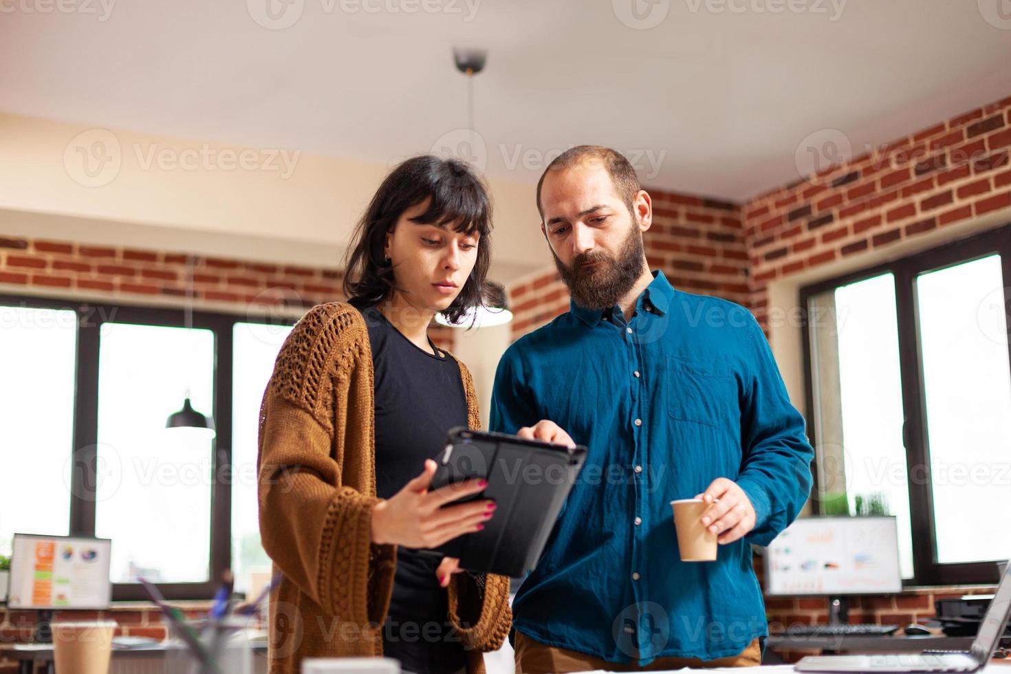 kvinna chef håller tablett dator visar företagsrapport till entreprenör man foto