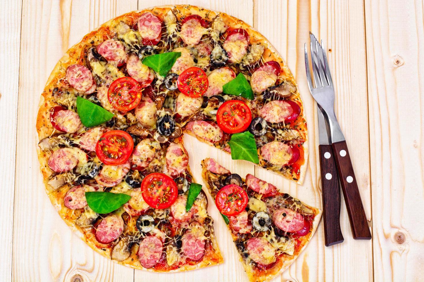 pepperoni pizza med korv, ost, mozzarella, oliver och bas foto