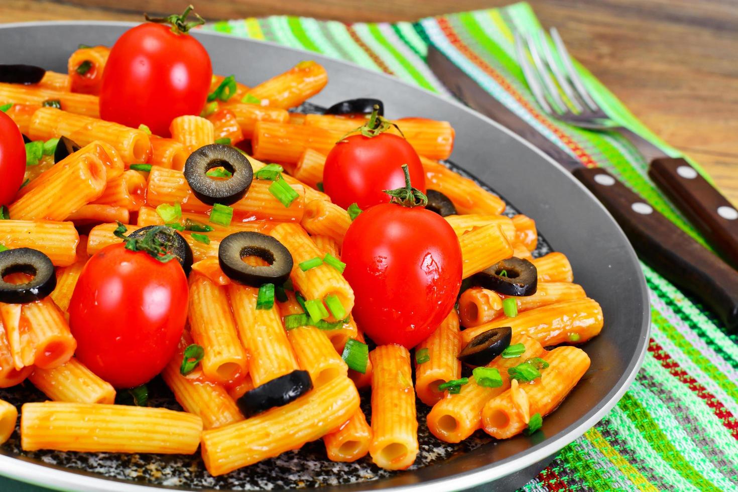 pasta med tomatketchupsås, salladslök och ost foto