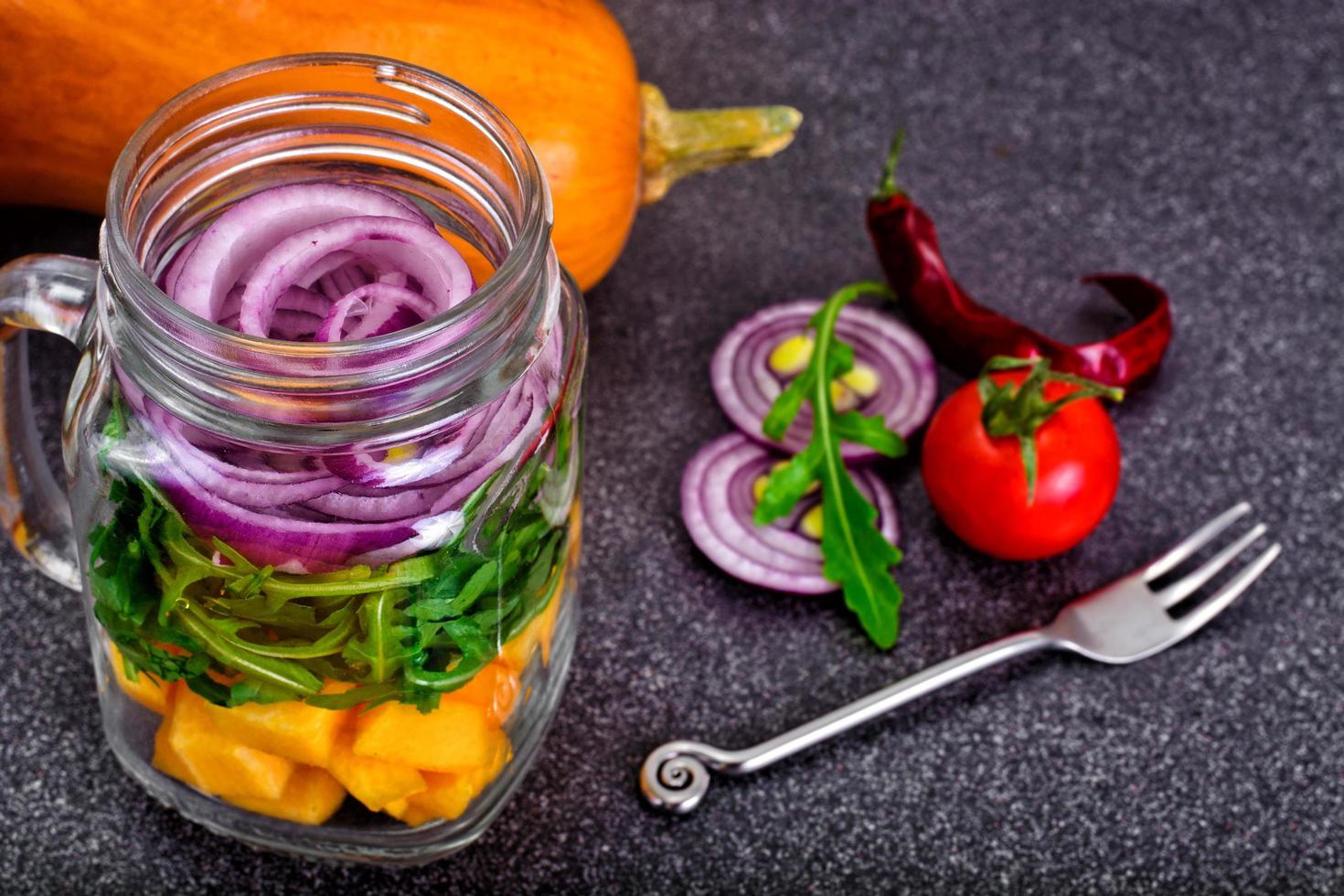 sallad med pumpa, ruccola och rödlök i glasburk foto