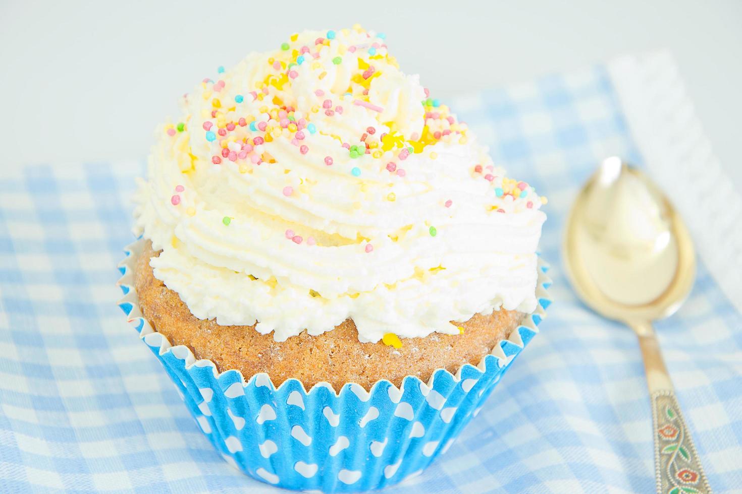 tårta med grädde, cupcake på blå bakgrund. foto