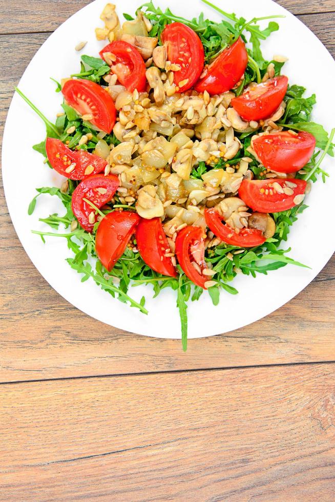 sallad med tomater, champinjoner, ruccola och frön foto