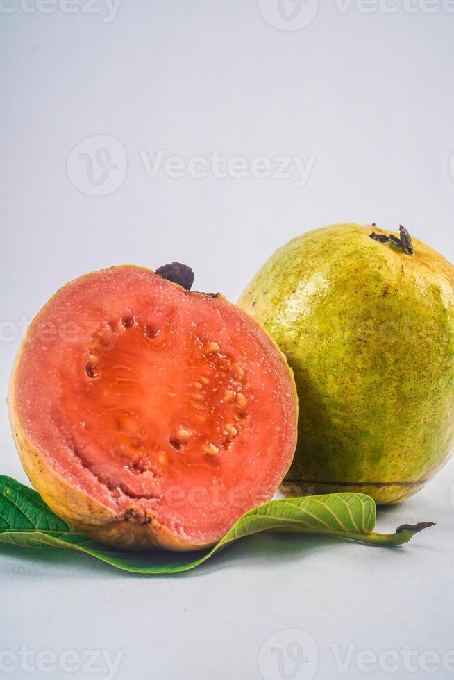 guava isolerat. samling av röd kött guava frukt med gulaktig grön hud på en blad isolerat på en vit bakgrund. foto