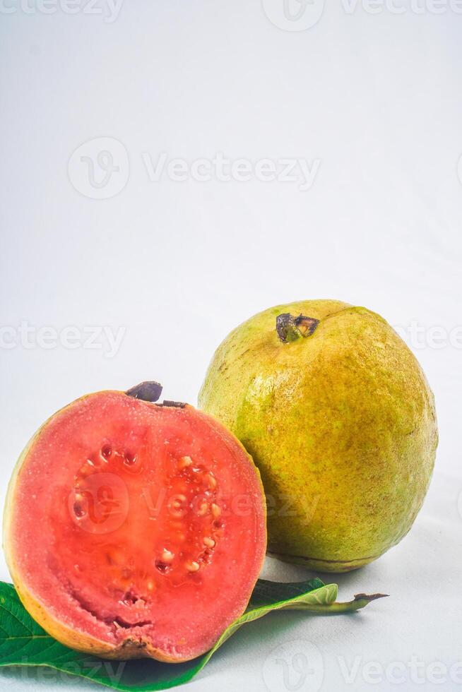 guava isolerat. samling av röd kött guava frukt med gulaktig grön hud på en blad isolerat på en vit bakgrund. foto
