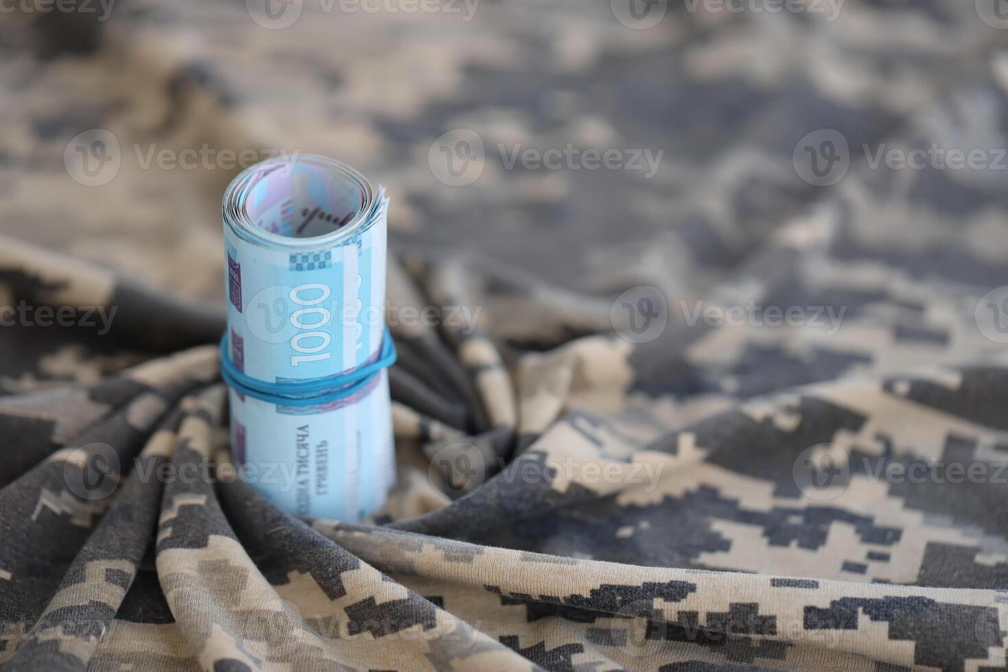 ukrainska hryvnian räkningar på tyg med textur av ukrainska militär pixeled kamouflage. trasa med camo mönster i grå, brun och grön pixel former. officiell enhetlig av ukrainska soldater foto