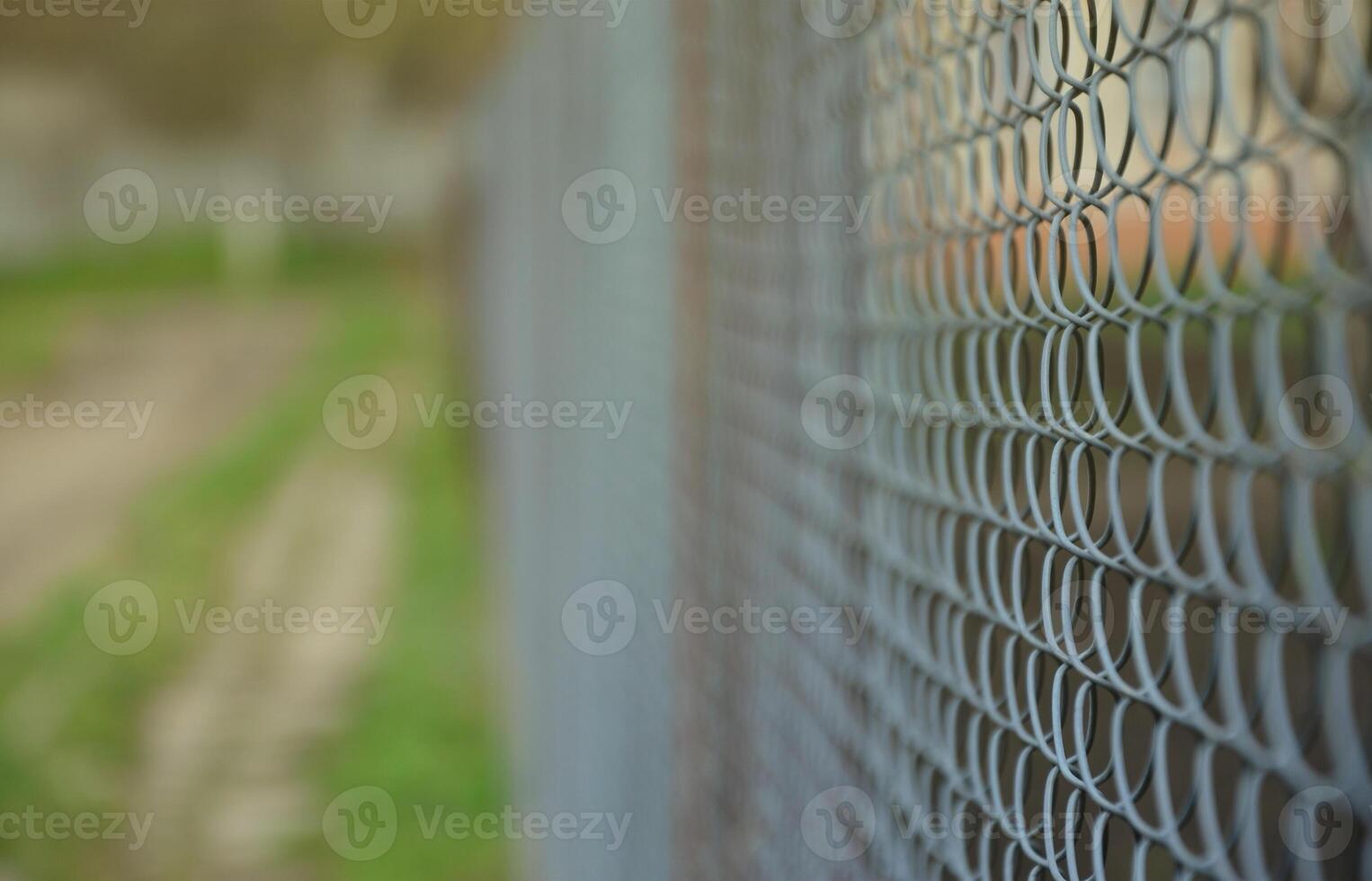 en fotografera av en metall netto Begagnade som en staket av privat ägodelar. gammal metall rutnät i perspektiv med en suddig bakgrund foto