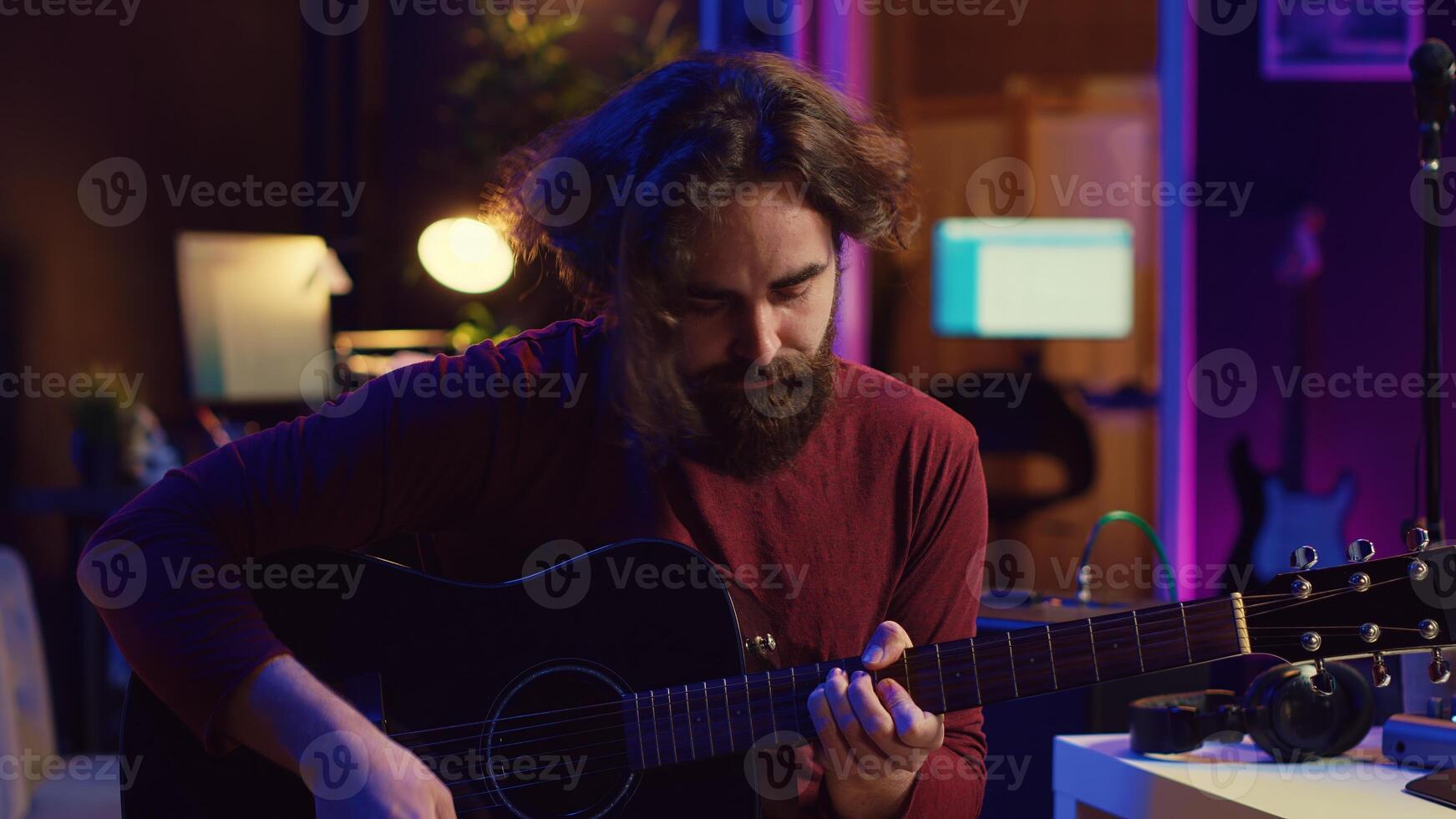 ung man spelar gitarr och skapande musik använder sig av utjämnare daw programvara gränssnitt. musik producent inspelning låt i Hem studio och blandning akustisk ljud på stereo trösta. kamera a. foto