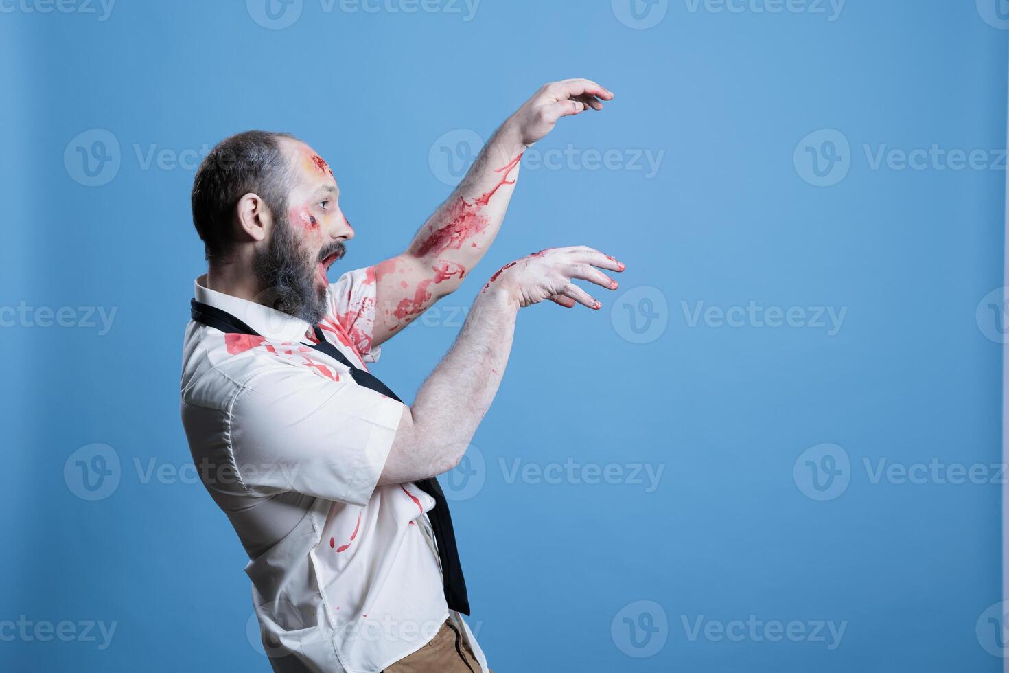 besatt man täckt i blod vände sig in i zombie efter varelse dödade, efterhängsen plats. sårad makaber kadaver slappt gående mot offer, framställning för ge sig på, studio bakgrund foto
