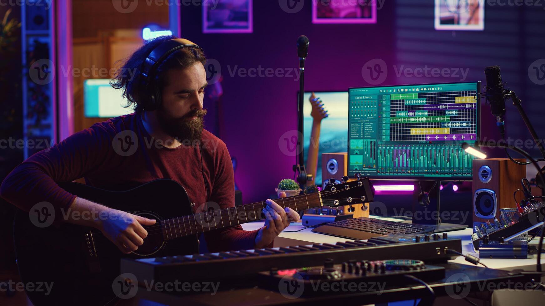 låtskrivare musiker spelar gitarr och elektronisk piano tangentbord i Hem studio, inspelning akustik med monitorer blandning redskap till producera ny modern sånger. utjämnare och daw programvara. kamera a. foto