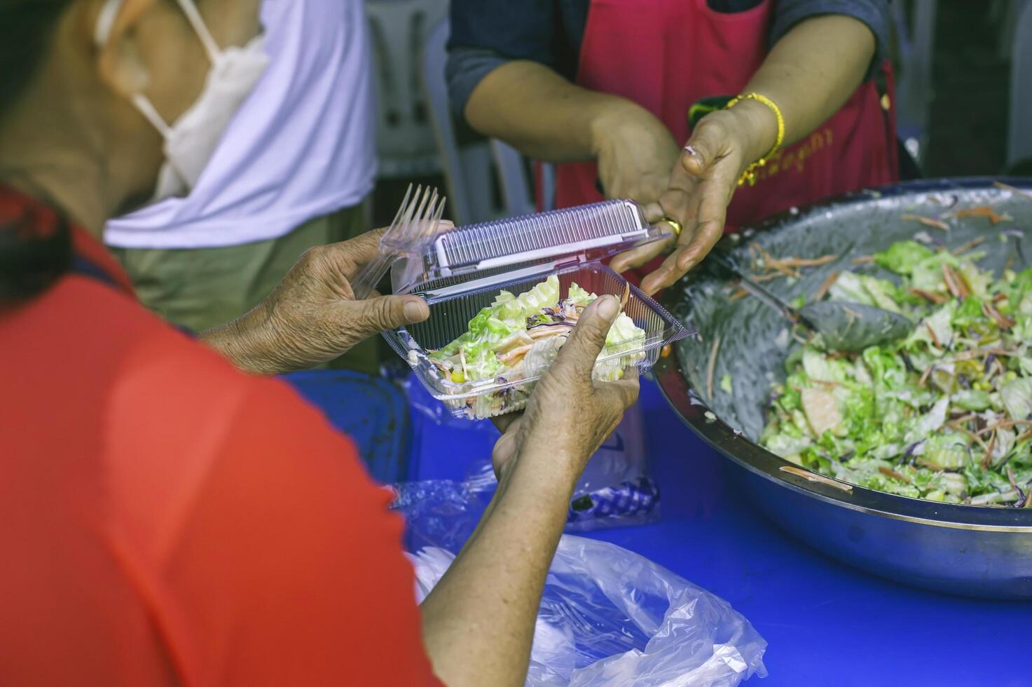 matning begrepp hemlös människor erbjudande fri mat från utomhus- frivilliga. foto