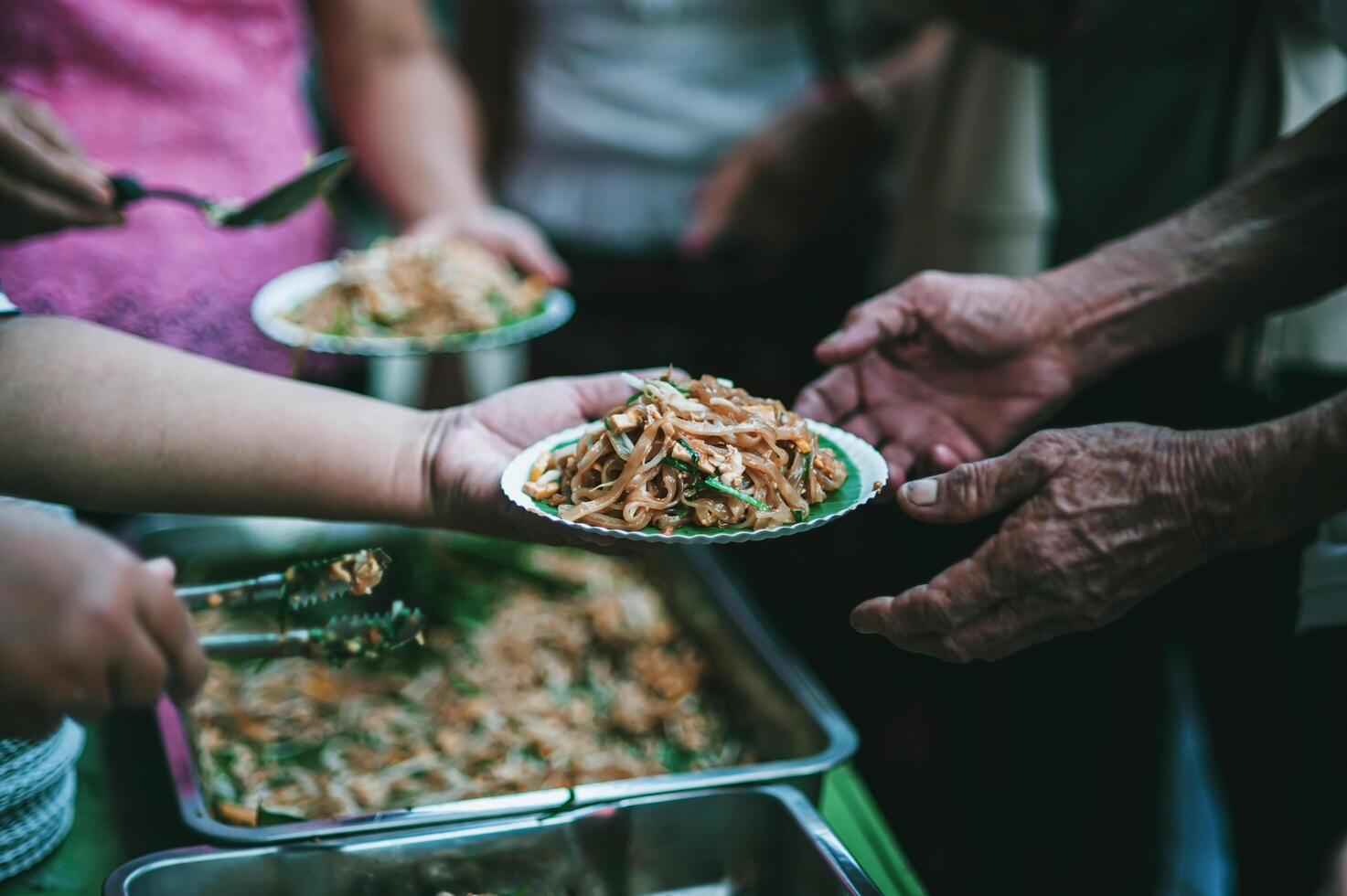 volontärer är ger fri mat till hjälp de hungrig fattig begrepp av mat delning foto