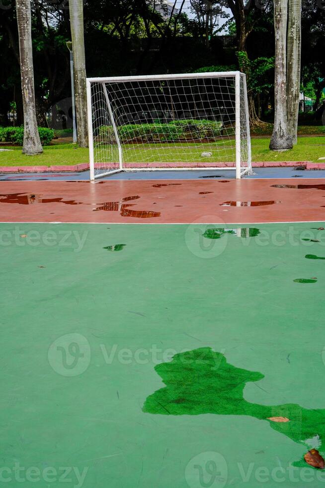 vattenpölar av vatten på de futsal fält mål efter regn. foto