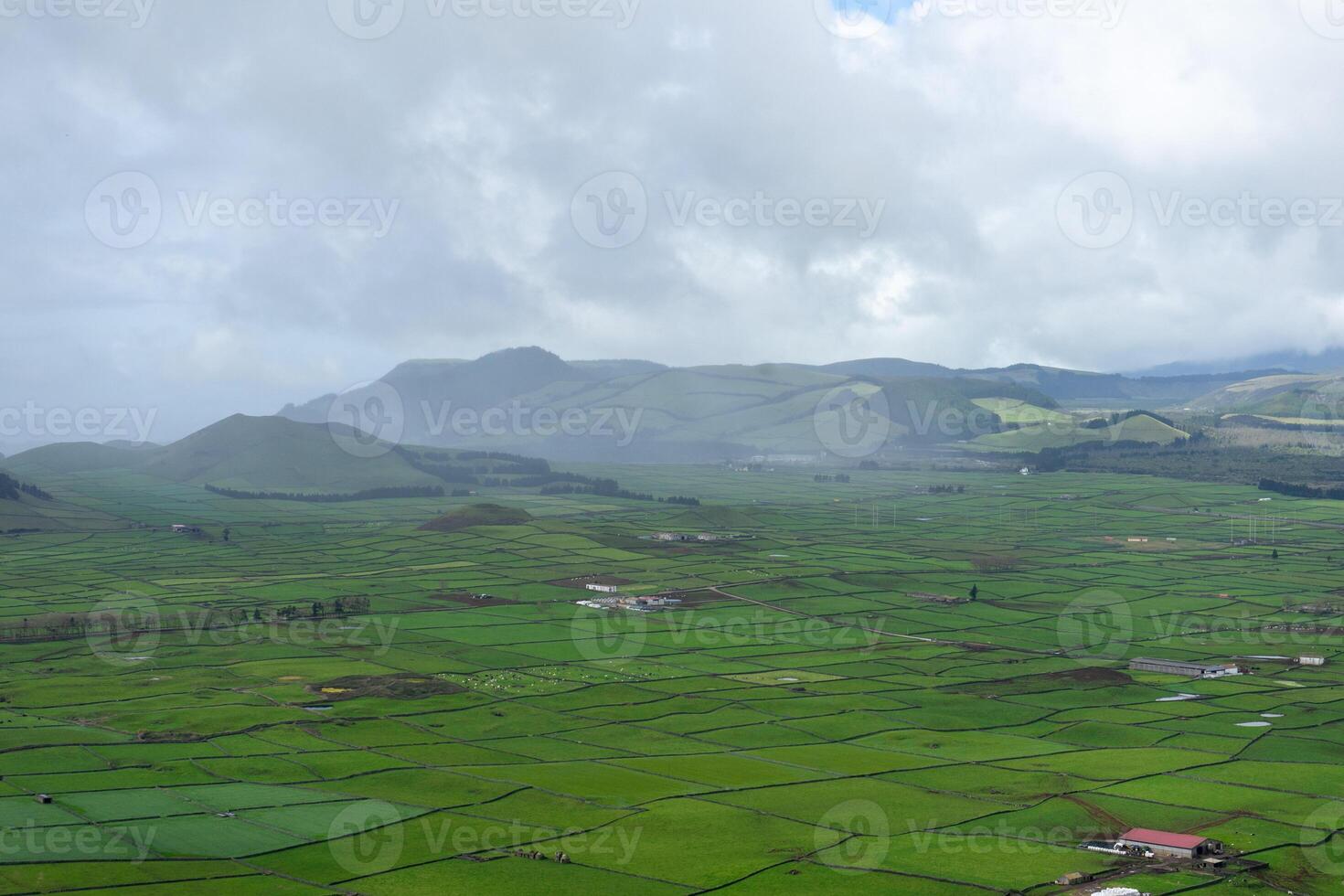 naturskön se av frodig betesmarker i terceira ö, Azorerna, inramade förbi svart sten väggar, med bergen i de bakgrund. foto
